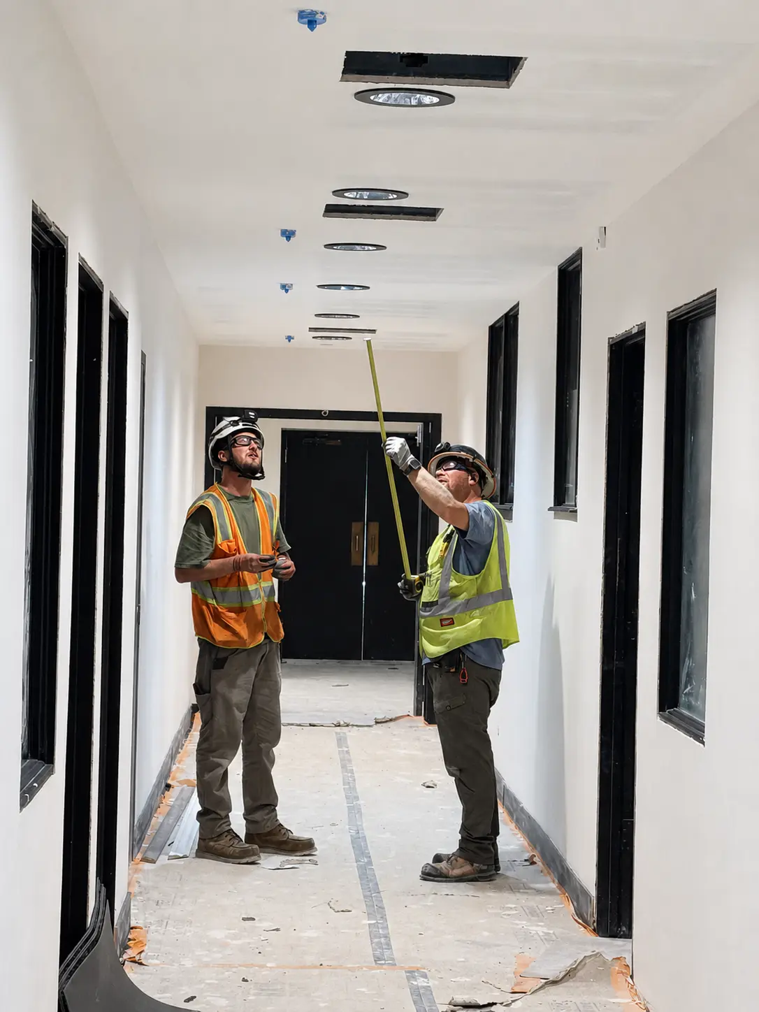 Electricians laying out corridor lighting at BRAVE Church