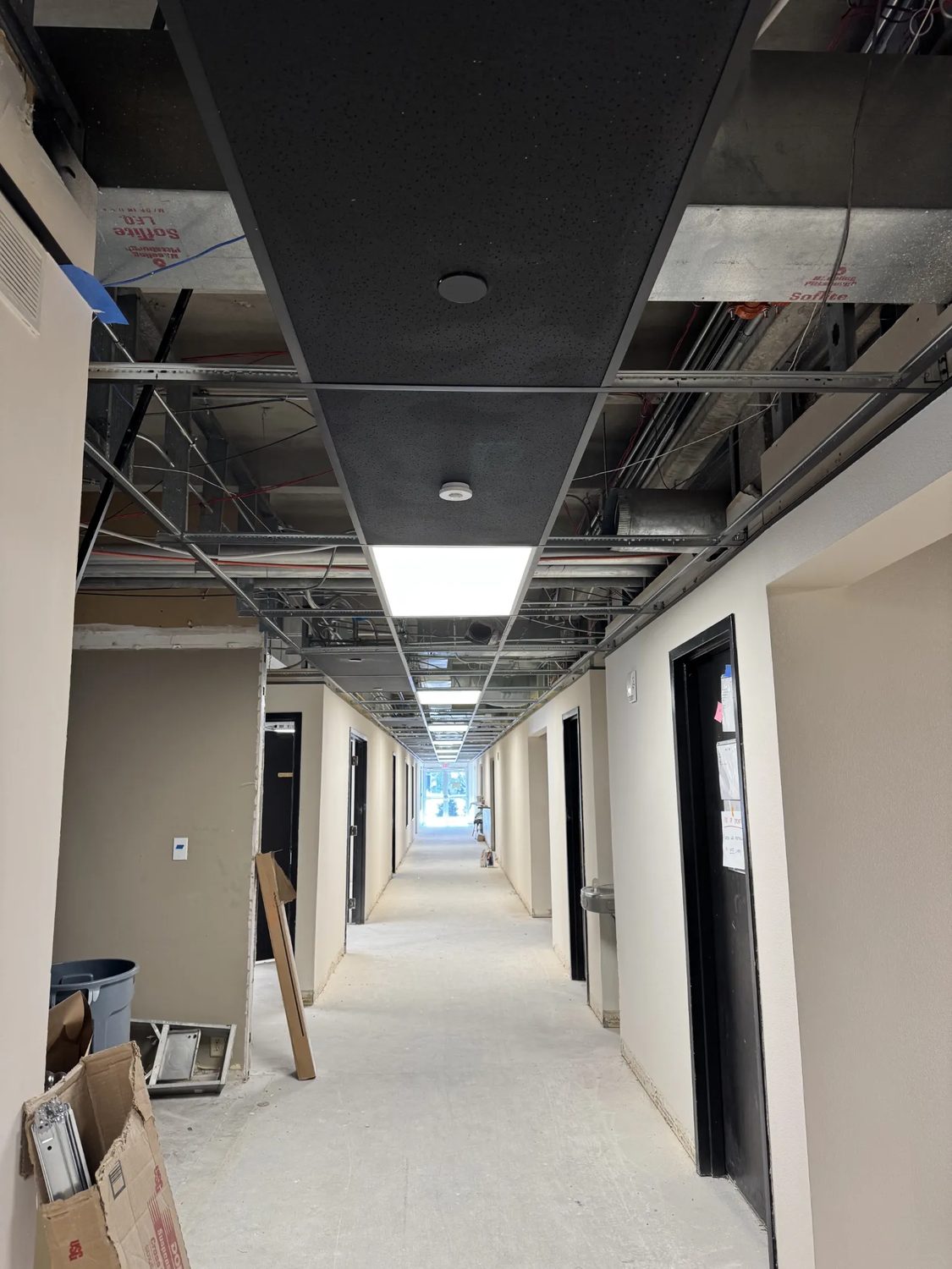 Corridor ceiling grid and lighting rough-in in progress at BRAVE Church